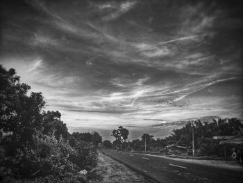 View of railway tracks along landscape and trees against sky