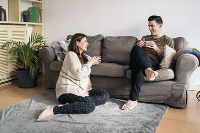 Friends sitting on sofa at home