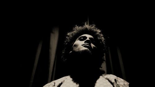 Low angle view of young man standing in darkroom