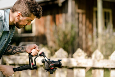 Side view of young man holding bicycle