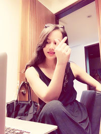 Portrait of beautiful young woman sitting at home