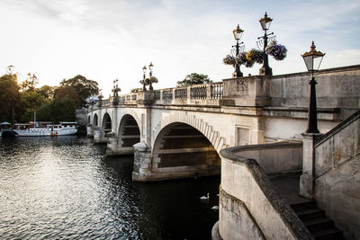 Arch bridge over river against sky