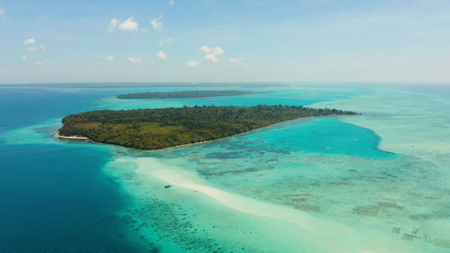 Island with a sandy beach and azure water surrounded by a coral reef. mansalangan sandbar, balabac