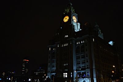 Low angle view of illuminated buildings against sky at night