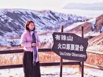 Portrait of woman standing on snow covered mountain