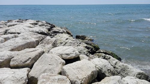 Rocks on sea shore against sky