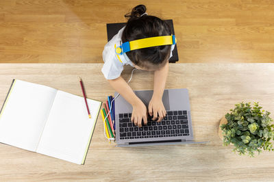 High angle view of girl reading book at home
