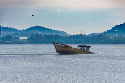 Boat on sea shore against sky