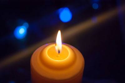 Close-up of lit candle in the dark