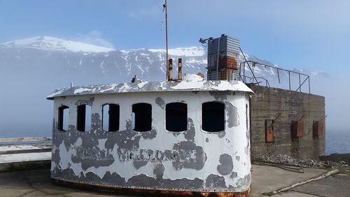 Built structure on snow covered mountain against sky