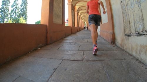 Low section of woman walking on footpath