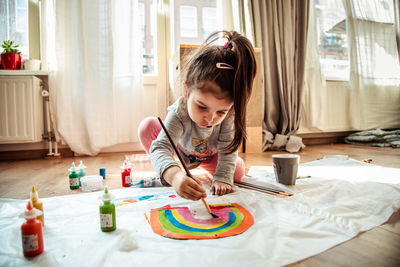 Girl painting on textile at home