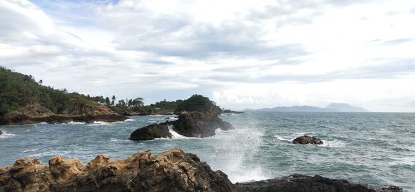 Scenic view of rocks in sea against sky