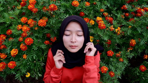 Young woman in headscarf against flowering plant