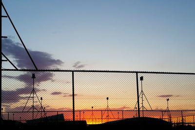 Silhouette fence against clear sky at sunset