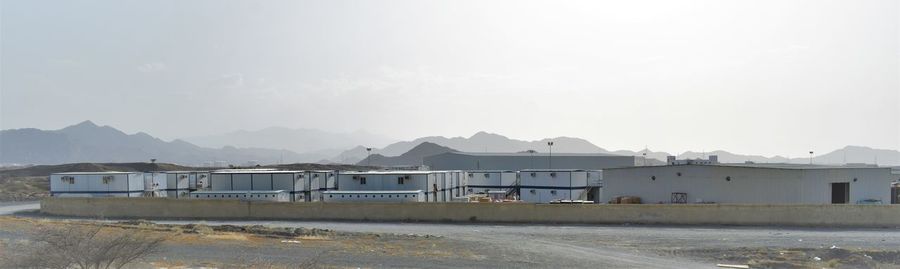 Houses by building against clear sky