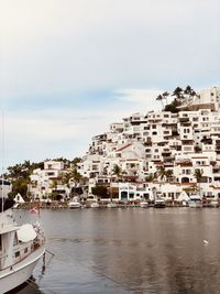 Buildings by sea against sky