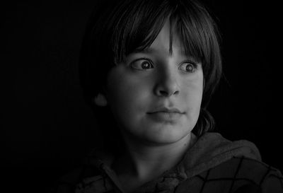 Close-up portrait of boy against black background