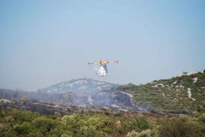 Low angle view of airplane flying against clear blue sky