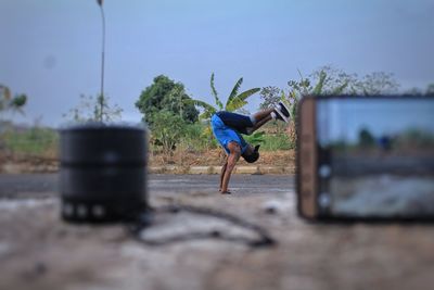 Close-up of mobile phone on table with man dancing in background