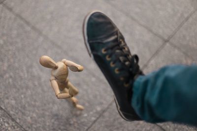 Low section of man stepping on figurine