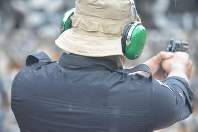 Rear view of man wearing hat standing outdoors