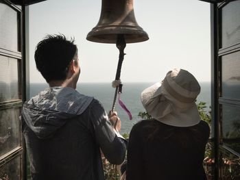 Rear view of couple ringing bell