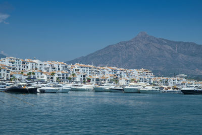 Sailboats in sea against clear blue sky