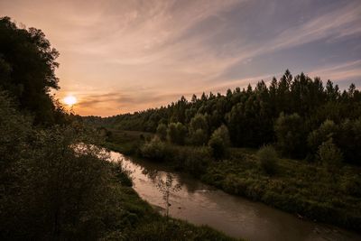 Scenic view of river against sky at sunset