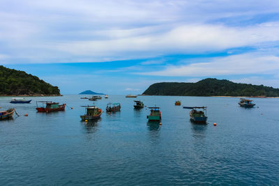 Boats moored on sea against sky