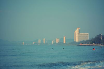 Sea and buildings against clear sky