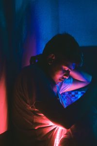 Man sleeping in illuminated room