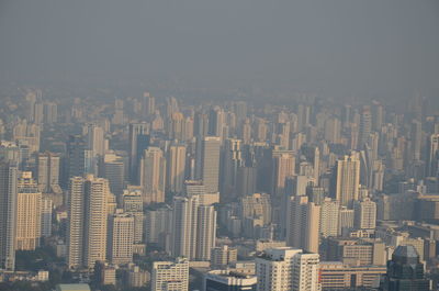 Aerial view of buildings in city against sky