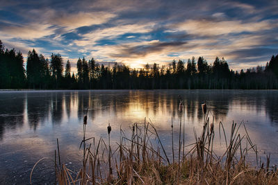 Landscape view of a frozen lake at sunset under cloudy sky