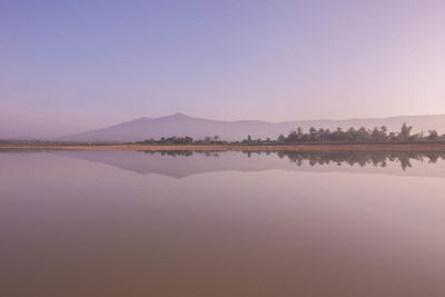 Scenic view of lake against clear sky during sunset