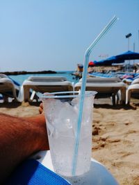 Midsection of man on beach against clear sky
