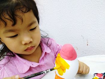 Close-up of cute girl painting at table