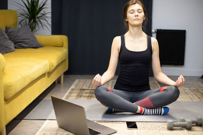 Full length of woman sitting at home