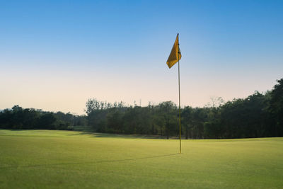 Scenic view of golf course against clear sky