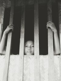 Portrait of girl looking through window