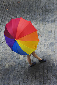 High angle view of woman with colorful umbrella on footpath