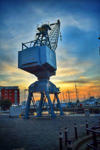 Cranes at harbor during sunset