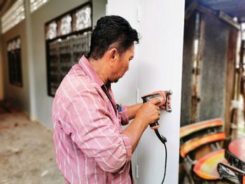 Construction worker drilling wall