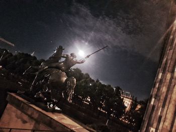 Statue in city at night