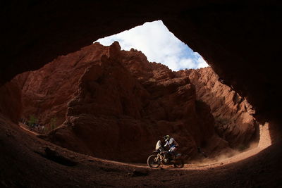 Person riding motorcycle against rocky mountains