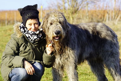 Portrait of woman with irish wolfhound on field