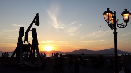 Silhouette people against sky at sunset