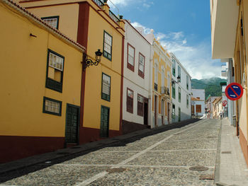 Street amidst buildings against sky in city