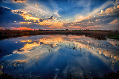 Scenic view of lake against sky at sunset