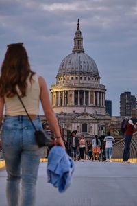 People at cathedral against sky in city